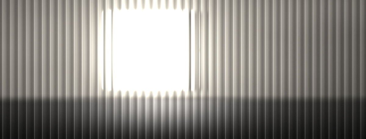 A wall of reeded glass, each flute slicing the daylight behind it into a separate vertical band.